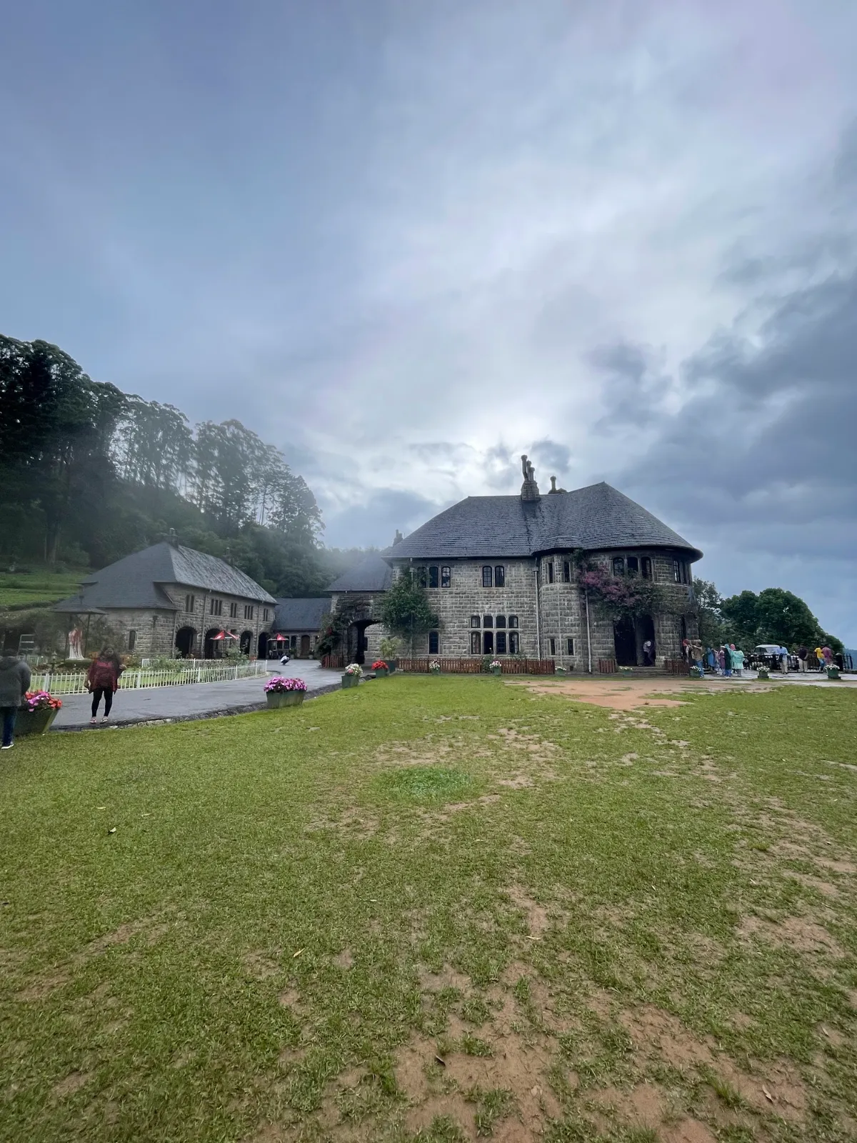 The grey stone Adisham Bungalow and its lawn in the misty hills of Haputale