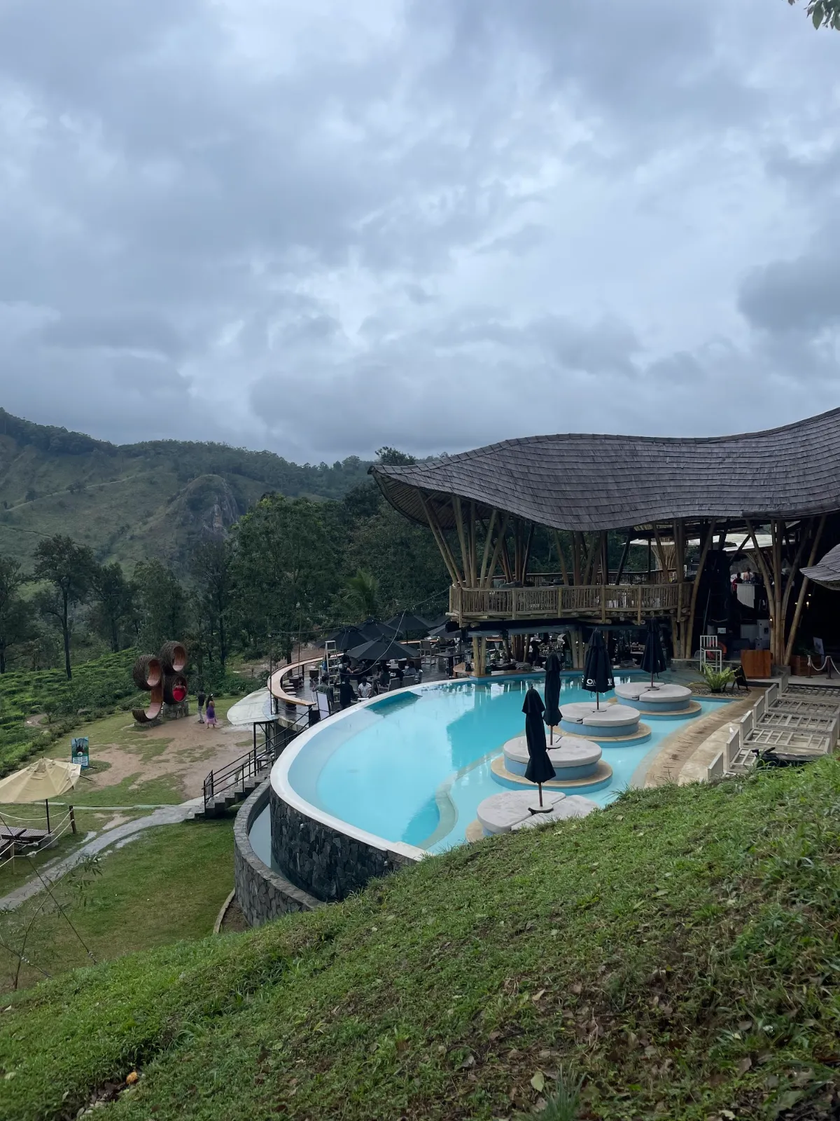 An infinity pool and bamboo pavilions on a hillside above Ella