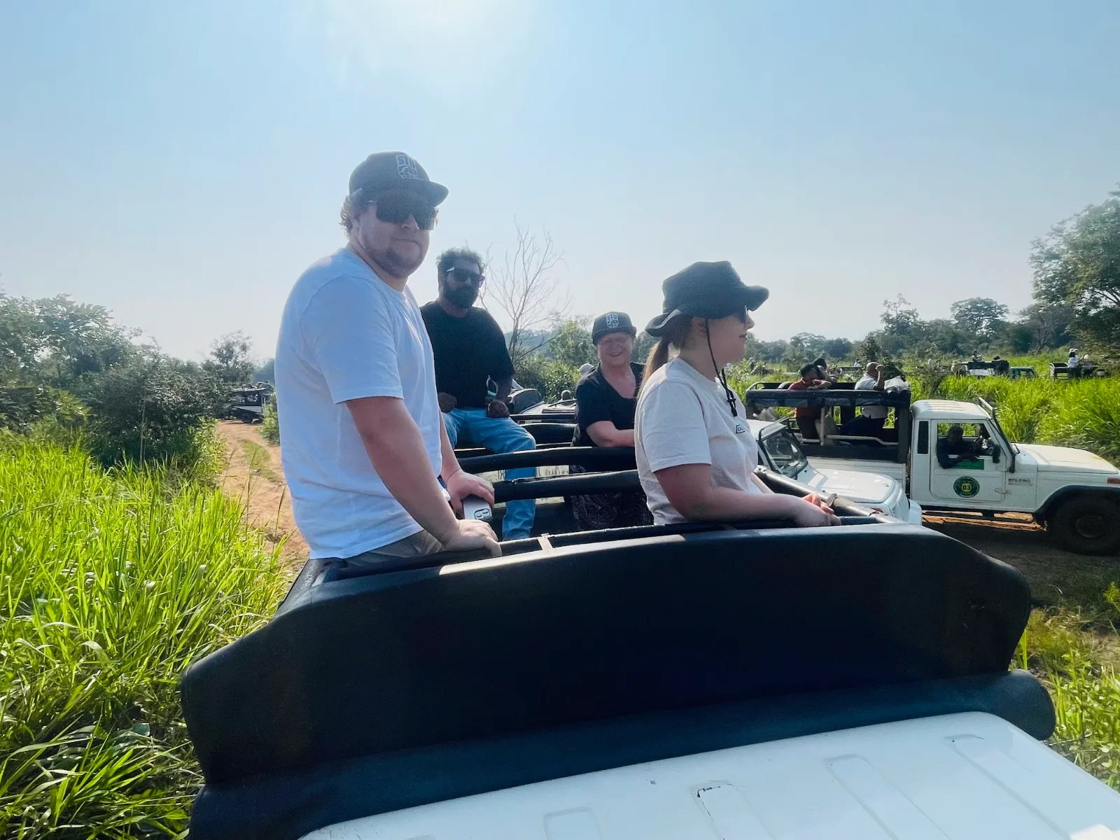 Guests sitting up in an open safari jeep looking out over the grassland near Habarana